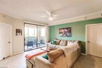 Living area with ceiling fan, light tile patterned flooring, and ornamental molding