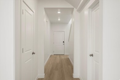 Hallway with light wood-style flooring and recessed lighting