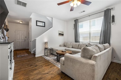 Living room featuring stairs, a ceiling fan, dark wood finished floors, and baseboards