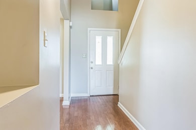 Entryway with hardwood / wood-style floors and baseboards