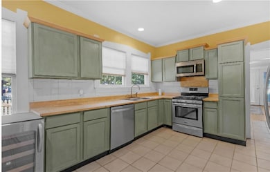 Kitchen featuring sink, green cabinetry, decorativ