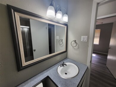Bathroom featuring vanity, wood finished floors, and a textured wall