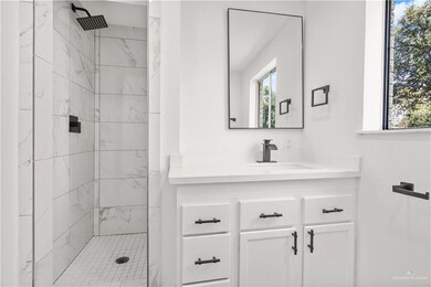 Full bath featuring a marble finish shower and vanity
