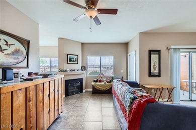 Living area featuring a ceiling fan, light tile pa