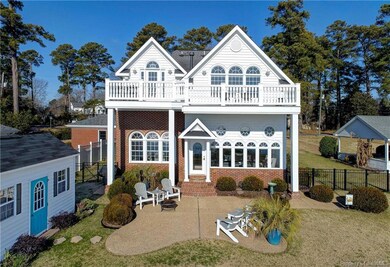 Rear exterior features patio, balcony and wall of windows.  Home situated well above sea level, no flood insurance required!