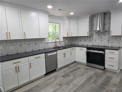 Kitchen featuring wall chimney exhaust hood, dishw