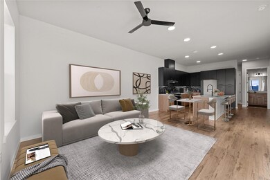 Living area featuring ceiling fan, light wood-sty