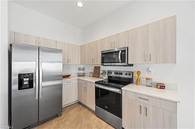 Kitchen featuring light countertops, light brown c
