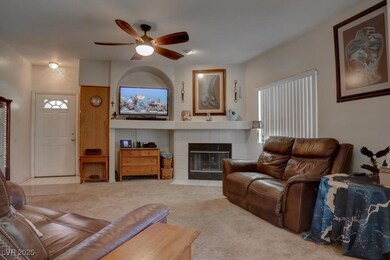 Carpeted living room featuring ceiling fan and a t