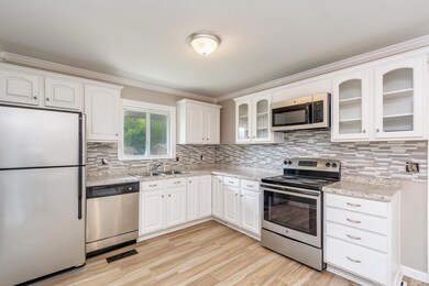 Completely updated kitchen with stainless steel appliances, modern backsplash, and new cabinets/counter tops  