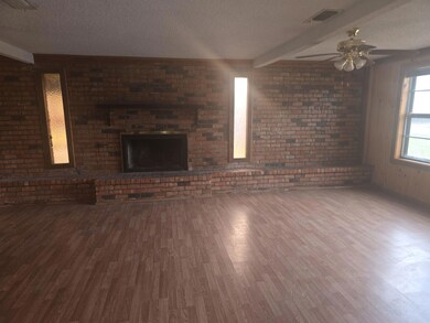 Unfurnished living room featuring a brick fireplac