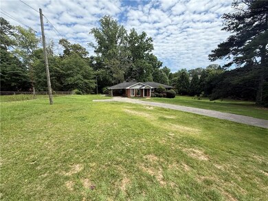 View of front of property with driveway and a carport
