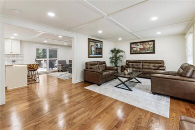 Living room featuring coffered ceiling, light wood-style flooring, and recessed lighting