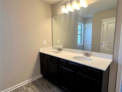 Full bathroom featuring double vanity and baseboards