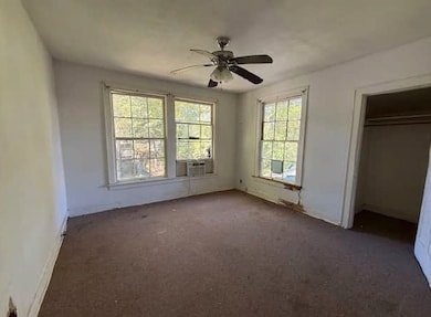 Unfurnished bedroom featuring carpet and a ceiling fan