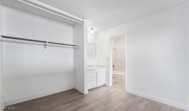 bedroom with a sink, wood finished floors, a textu