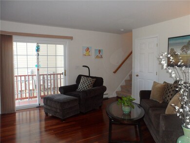 Living room with hardwood floors and sliders to pr