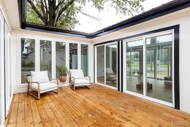 Sunroom / solarium featuring hardwood / wood-style flooring and wooden walls