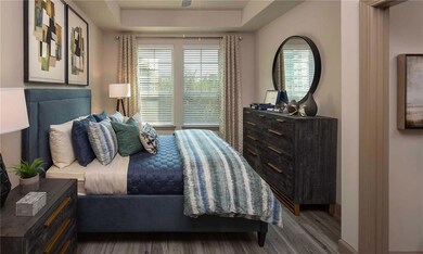 Bedroom with a tray ceiling and hardwood / wood-style flooring