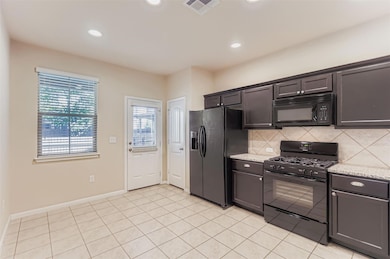 Kitchen featuring black appliances, recessed lighting, light stone countertops, light tile patterned floors, and backsplash