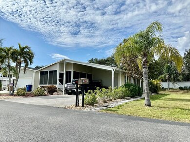 Manufactured / mobile home with a garage, a front lawn, and a carport
