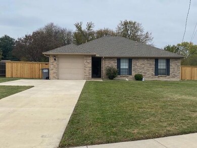Ranch-style house with a garage and a front lawn