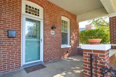 Property entrance featuring brick siding and a porch