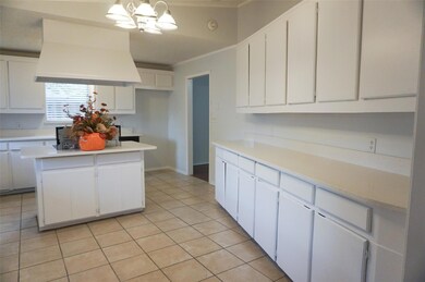 Kitchen featuring white cabinetry, a kitchen islan