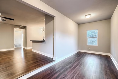 Unfurnished room with dark wood-style flooring, v