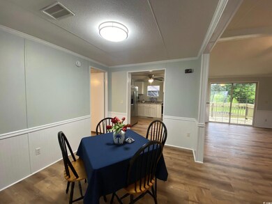 Dining space with wood finished floors, wainscotin