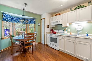 Kitchen with white appliances, white cabinetry, an
