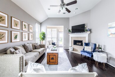 From this angle, we have a better view of the family room which includes a high angled ceiling and classic fireplace and mantel which round out this delightful family gathering area.