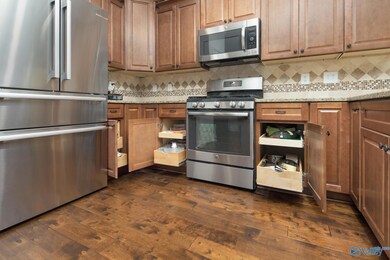 The kitchen boasts an array of high-quality features, including stunning granite countertops, Custom built and convenient pull-out drawers in every cabinet for effortless access