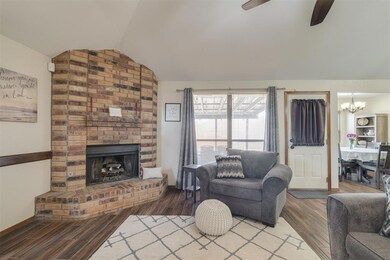 Living room featuring vaulted ceiling, a brick fir