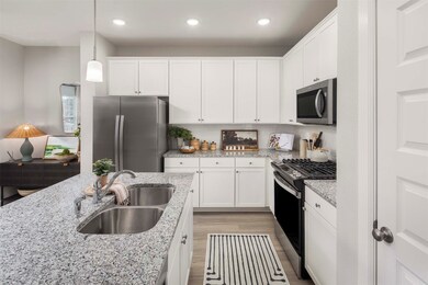 Kitchen with granite counters, white cabinets, gas