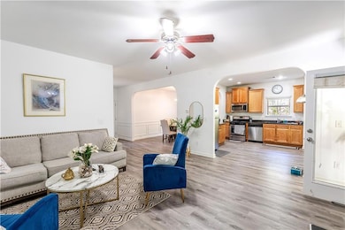 Living room with arched walkways, a ceiling fan, a