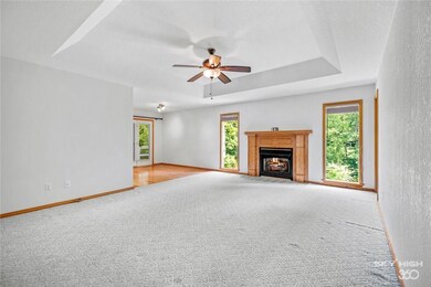 Large living room with trayed ceiling and fireplace