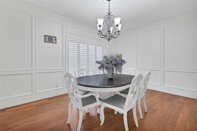 Bright dining room with elegant wainscoting and ha