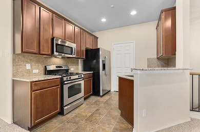 Kitchen featuring stainless steel appliances, tas