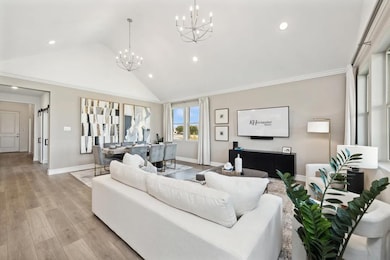Great room with vaulted ceiling and dual chandeliers 
