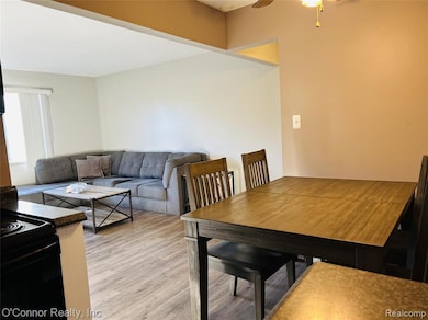 Dining space with light wood finished floors and ceiling fan