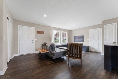 Living area featuring recessed lighting, baseboards, a textured ceiling, and dark wood finished floors