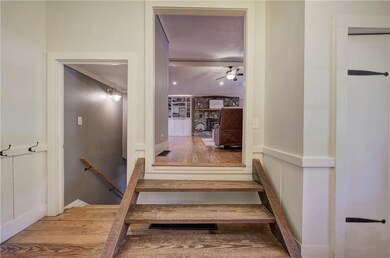 Stairs with ceiling fan, a wainscoted wall, a fire