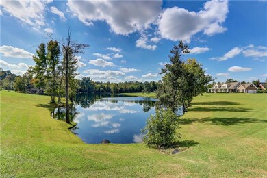 Another view of the lake showing the house to the right.  Gently sloping terrain through well established grass provides clean run-off into the water.