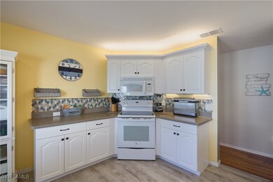 Kitchen with backsplash, light hardwood / wood-sty