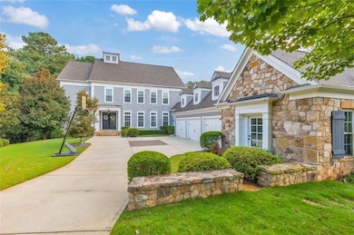 View of front of house with stone siding, concrete driveway, an attached garage, and a front yard