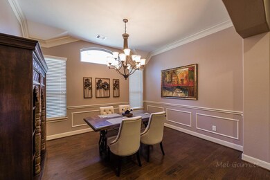 Formal dining room with wood flooring and stacked crown molding