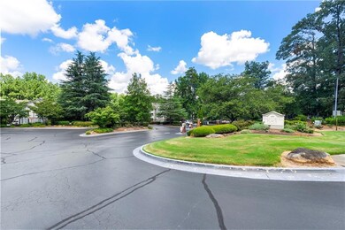 View of asphalt street featuring curbs and view of scattered trees