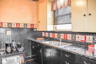 The kitchen has crown molding, wainscoting and a m