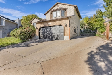 View of front facade featuring concrete driveway, brick siding, and an attached garage